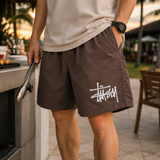 Stussy Basic Big Logo brown nylon shorts for casual wear, featuring a prominent Stussy logo on the front.