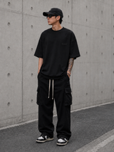 Black Fear of God Essentials Pique Signature 90s Tee displayed, featuring a classic casual fit and logo branding.
