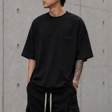 Black Fear of God Essentials Pique Signature 90s Tee, casual men's apparel with classic fit and minimalist design.