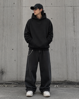 Black Fear of God Essentials hoodie with applique box logo, featuring a relaxed fit and modern streetwear style.