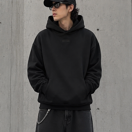 Black Fear of God Essentials hoodie with applique box logo, casual apparel featuring a front graphic, comfortable and stylish.