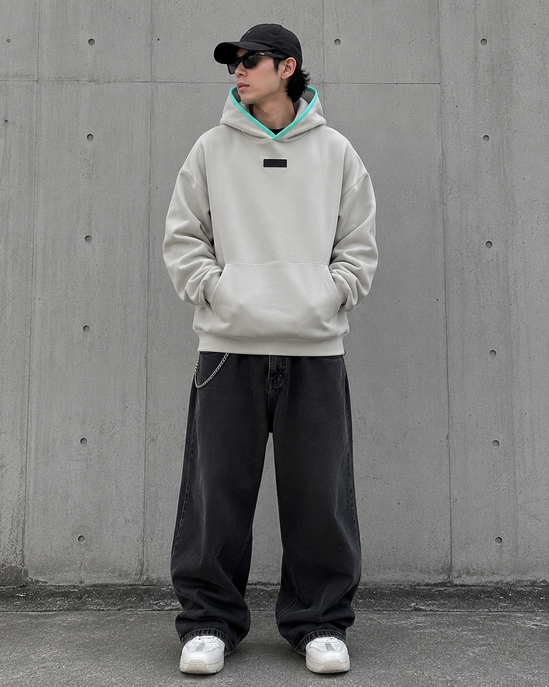 Fear of God Essentials box logo hoodie with appliqué design, featuring a seal logo on the front, casual streetwear style.