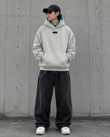 Fear of God Essentials box logo hoodie with appliqué design, featuring a seal logo on the front, casual streetwear style.