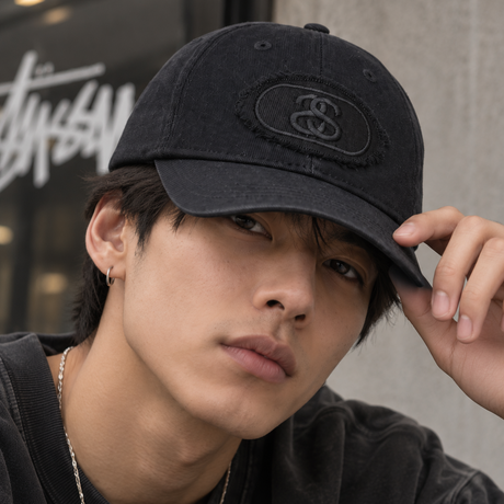 Black Stussy Pill Logo snapback hat featuring a curved brim and adjustable strap, styled as a casual streetwear headwear accessory.