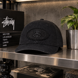Black Stussy Pill Logo Snapback cap, a stylish headwear accessory featuring the iconic Stussy branding and adjustable snap closure.