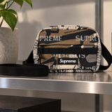 Supreme Reflective Monogram Logo Mini Shoulder Bag with Predator Camo pattern, featuring adjustable strap and compact design.