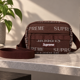 Supreme brown reflective monogram logo mini shoulder bag with adjustable strap and compact design.
