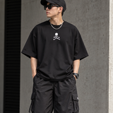 Black boxy fit T-shirt by MASTERMIND JAPAN featuring a front skull graphic, part of the Mastermind Japan X MOONRAKERS apparel collection.