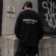 Black Fear of God Essentials Classic Long Sleeve Tee displayed flat, showcasing its simple, stylish design and crew neckline.