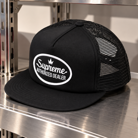 Black Supreme mesh trucker cap with adjustable snapback closure, featuring the Supreme logo on the front panel.