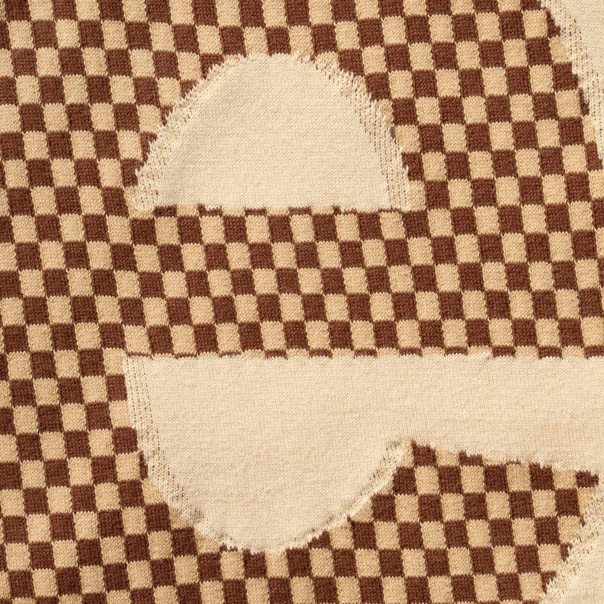 Supreme checkered intarsia tan t-shirt featuring a bold black and tan geometric pattern on soft cotton fabric.