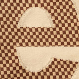 Supreme checkered intarsia tan t-shirt featuring a bold black and tan geometric pattern on soft cotton fabric.