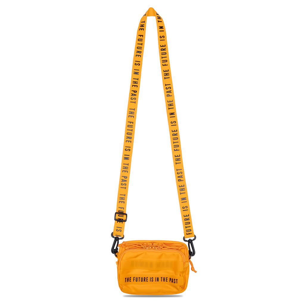 Yellow Human Made military mini sling bag with compact design, featuring adjustable strap and multiple compartments.