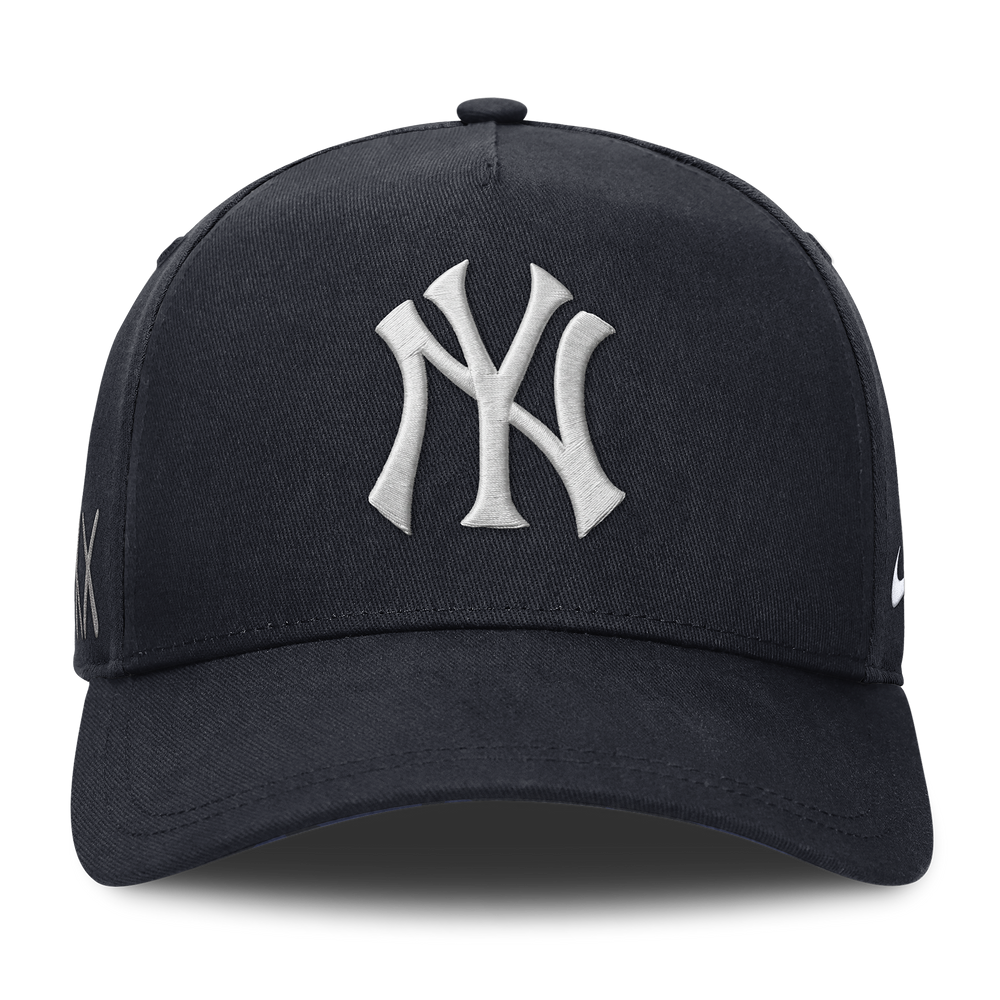 Structured AFRAME New York Yankees snapback cap by KAWS X Nike in navy with HUMAN MADE branding and Yankees logo.