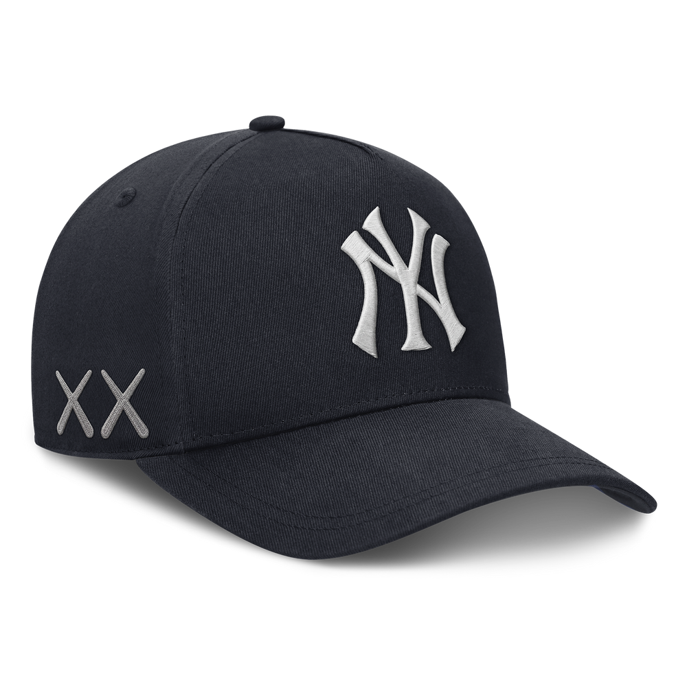 Structured navy New York Yankees snapback hat featuring KAWS x Nike branding and human-made design details.