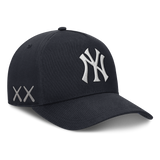 Structured navy New York Yankees snapback hat featuring KAWS x Nike branding and human-made design details.