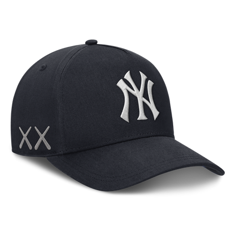 Structured navy New York Yankees snapback hat featuring KAWS x Nike branding and human-made design details.