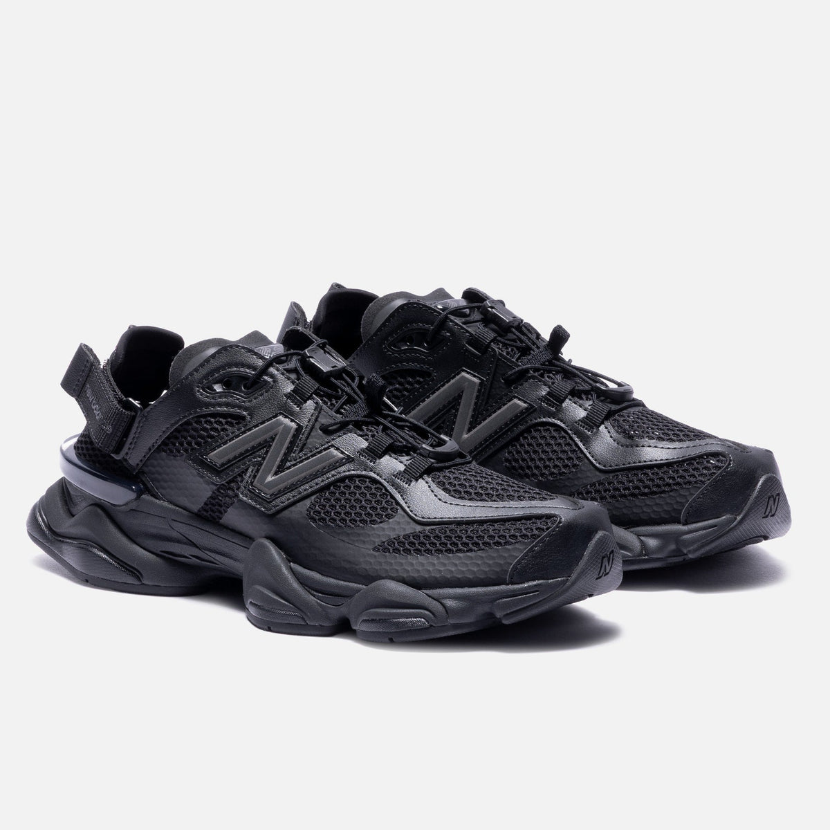 Black New Balance 9060 Mule sneakers with sleek design and comfortable fit, showcased from a side angle.