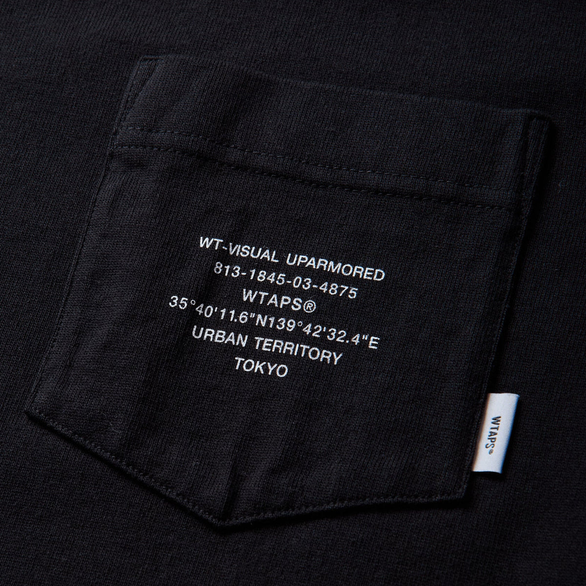 Black WTAPS Pocket Tee shirt with short sleeves and front pocket, made of cotton, displayed on a plain background.