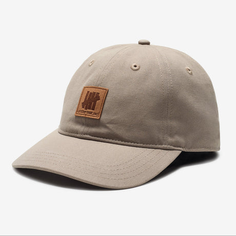 Undefeated Patch Logo Khaki Snapback hat featuring canvas material and adjustable snapback closure, styled in khaki color.