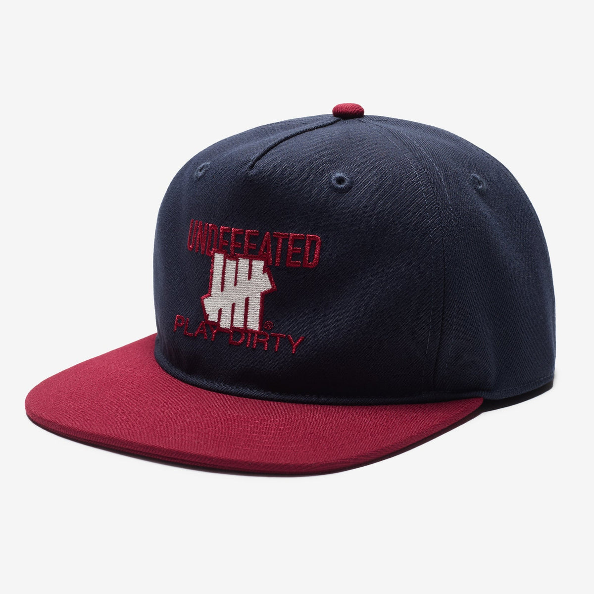 Undefeated Play Dirty navy and red snapback hat, stylish headwear with logo, viewed from front angle.