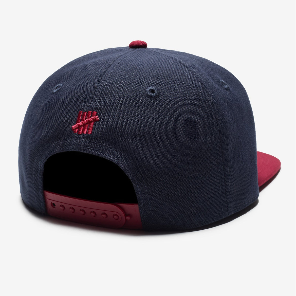 Undefeated Play Dirty Snapback hat in navy and red with adjustable brim and embroidered logo, stylish headwear accessory.
