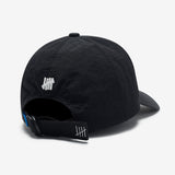 Black Undefeated logo strapback hat, a stylish headwear accessory with adjustable strap and embroidered brand logo.