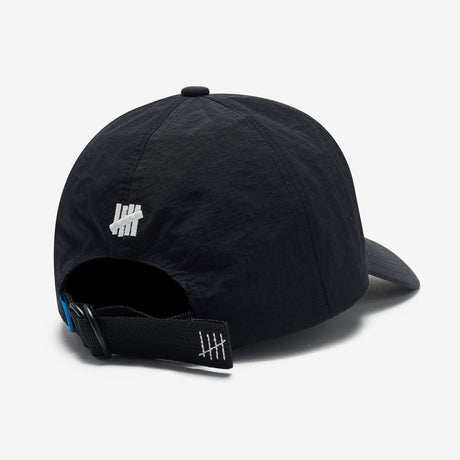 Black Undefeated logo strapback hat, a stylish headwear accessory with adjustable strap and embroidered brand logo.