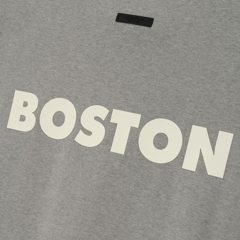 Fear of God Essentials NBA Celtics heavyweight T-shirt in concrete color, featuring team logo and 90s-inspired design.