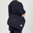 Black Carhartt messenger bag with ripstop fabric, adjustable strap, and multiple compartments for everyday carrying.