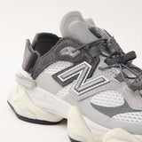 New Balance 9060 Mule Raincloud Castlerock sneakers with stylish design and textured gray material, indoor view.