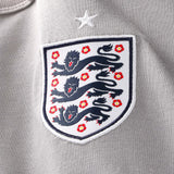 England Nike x Palace Pewter Grey T-shirt featuring Nike branding and England graphic, styled casually with a relaxed fit.