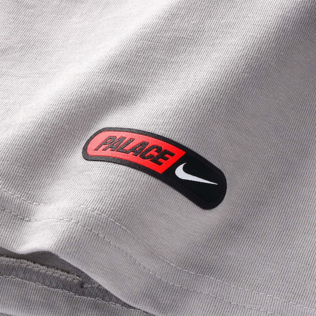 England Nike x Palace premium T-shirt in pewter grey, featuring Nike and Palace branding on soft cotton fabric.