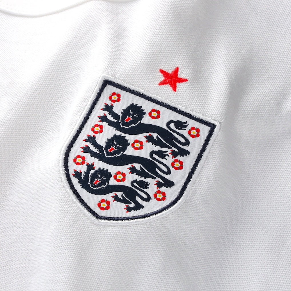 White Nike Palace x England tee shirt featuring England logo and branding, displayed flat with visible collar and graphic design.
