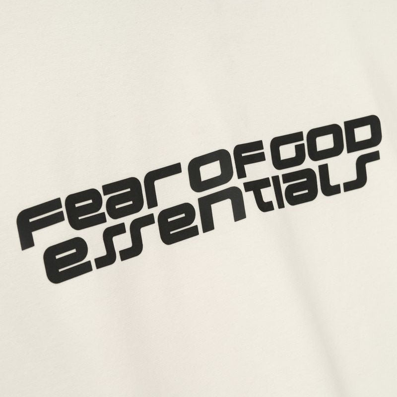 Fear of God Essentials Reflective Logo Ponte 90s Tee in ivory, featuring upgraded fabric and reflective branding, casual streetwear style.