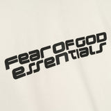 Fear of God Essentials Reflective Logo Ponte 90s Tee in ivory, featuring upgraded fabric and reflective branding, casual streetwear style.
