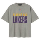 Fear of God Essentials X Lakers NBA 90s heavyweight tee in concrete, unisex apparel featuring Lakers logo and vintage-inspired design.