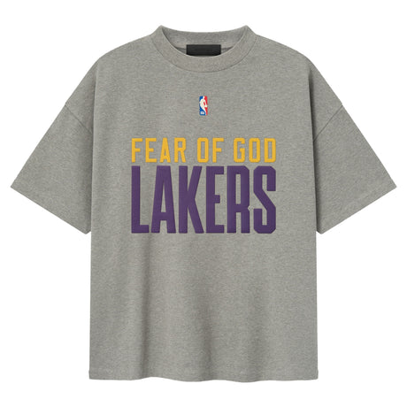 Fear of God Essentials X Lakers NBA 90s heavyweight tee in concrete, unisex apparel featuring Lakers logo and vintage-inspired design.
