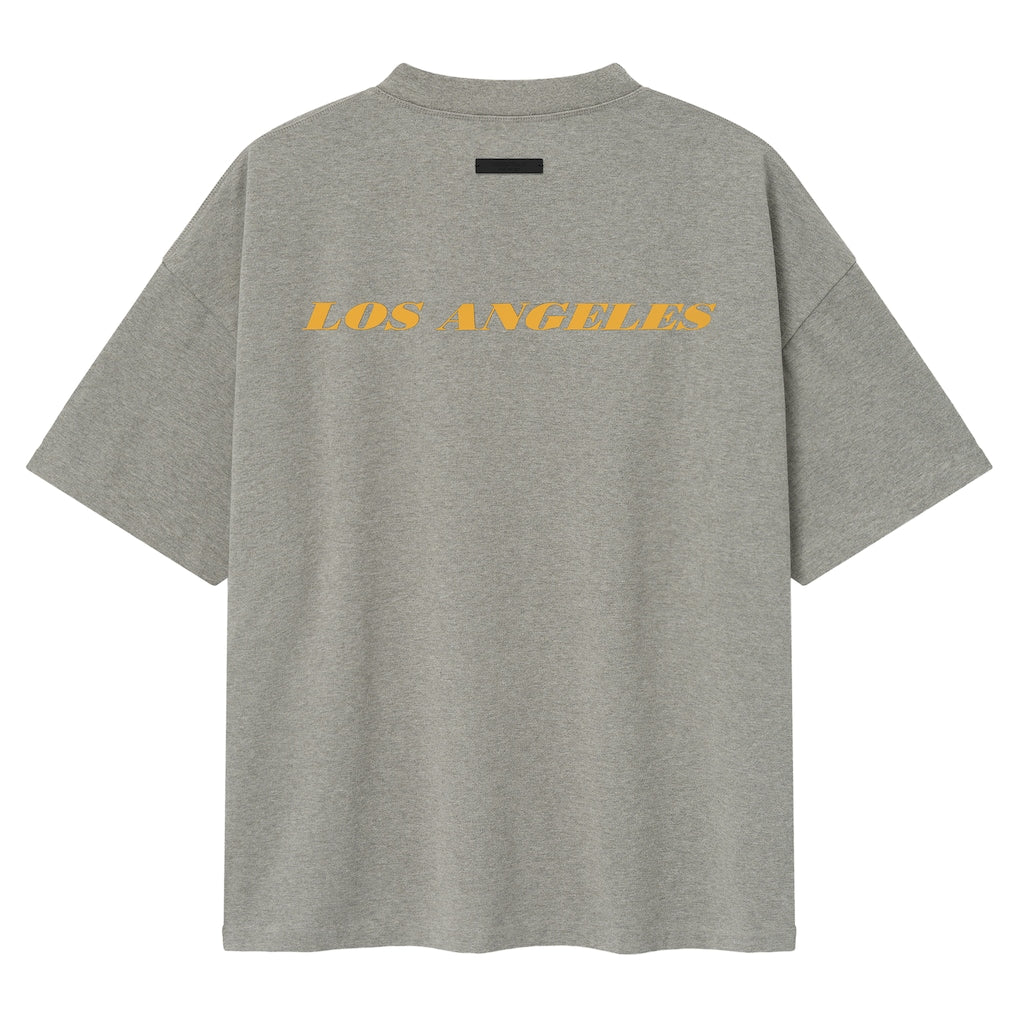Fear of God Essentials Lakers NBA 90s Heavyweight Tee in concrete, unisex basketball-inspired t-shirt with Lakers logo and vintage style.