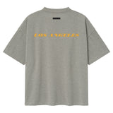 Fear of God Essentials Lakers NBA 90s Heavyweight Tee in concrete, unisex basketball-inspired t-shirt with Lakers logo and vintage style.