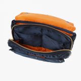 Porter Yoshida Japan Tanker Envelope Bag in navy with leather trim, showcasing its sleek, compact design and durable fabric.