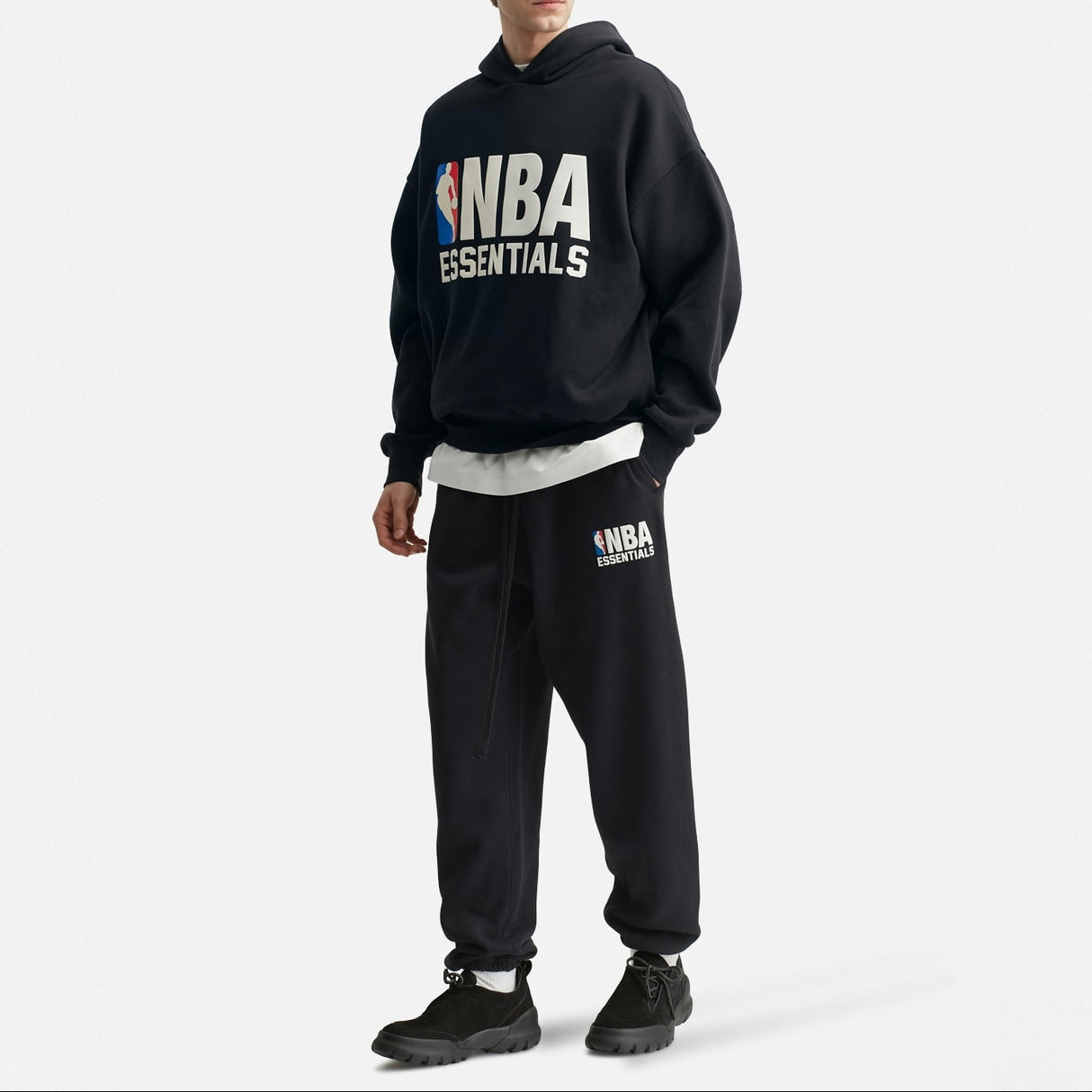 Black Fear of God Essentials X NBA sweatpants with logo details, relaxed fit, made of soft cotton fabric, casual athletic wear.
