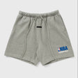 Fear of God Essentials NBA logo sweat shorts in concrete heather, featuring a relaxed fit and branded NBA patch on the side.