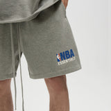 Fear Of God Essentials NBA logo sweat shorts in concrete heather, featuring relaxed fit and sporty design, casual apparel for everyday wear.