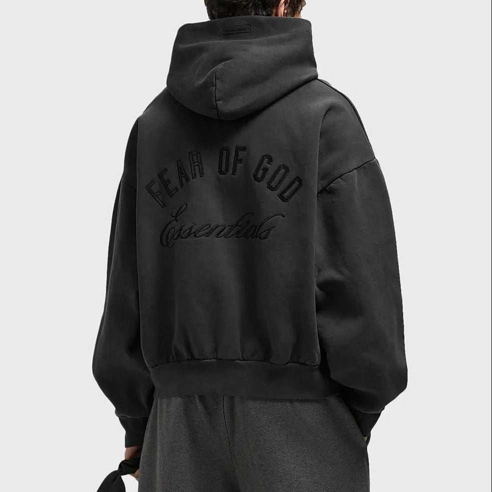Fear of God Essentials Logo Classic Zip-up Hoodie in vintage black fabric, featuring a front zip and brand logo detail.
