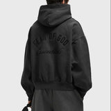 Fear of God Essentials Logo Classic Zip-up Hoodie in vintage black fabric, featuring a front zip and brand logo detail.