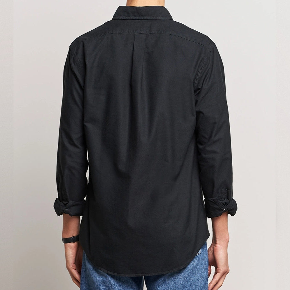 Black Polo Ralph Lauren classic fit Oxford long sleeve shirt displayed on a hanger, showcasing its collar and button details.