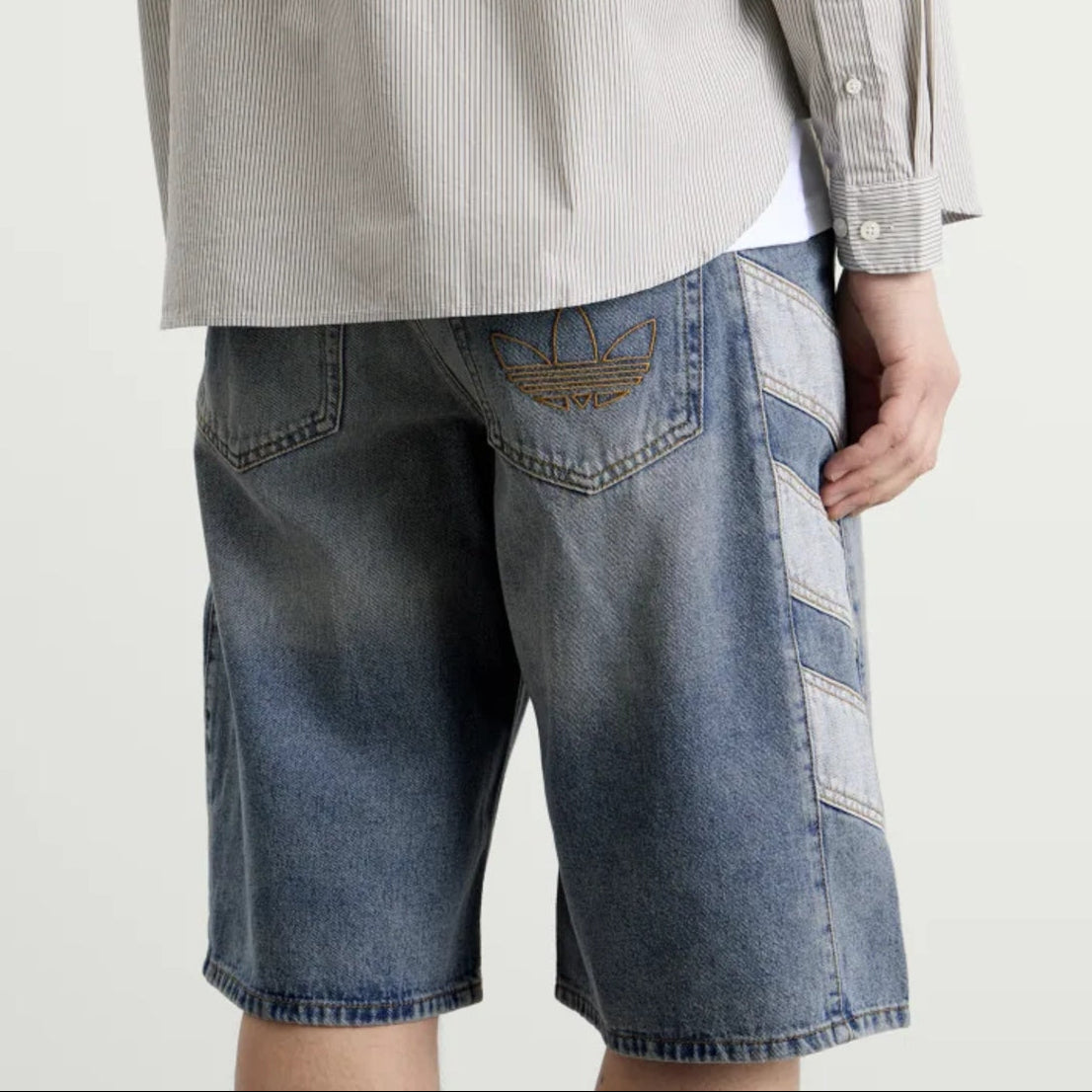 Pair of Adidas denim shorts in classic indigo color, featuring a casual fit and stylish design for everyday wear.