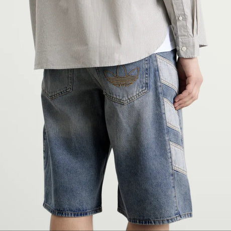 Pair of Adidas denim shorts in classic indigo color, featuring a casual fit and stylish design for everyday wear.
