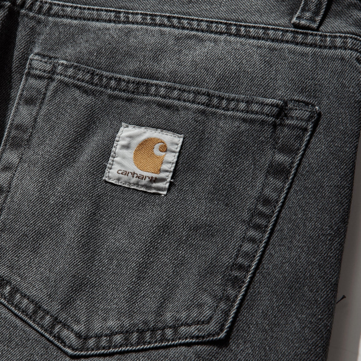 Carhartt WIP Landon jeans in blue-black denim with worn, bleached finish and relaxed fit